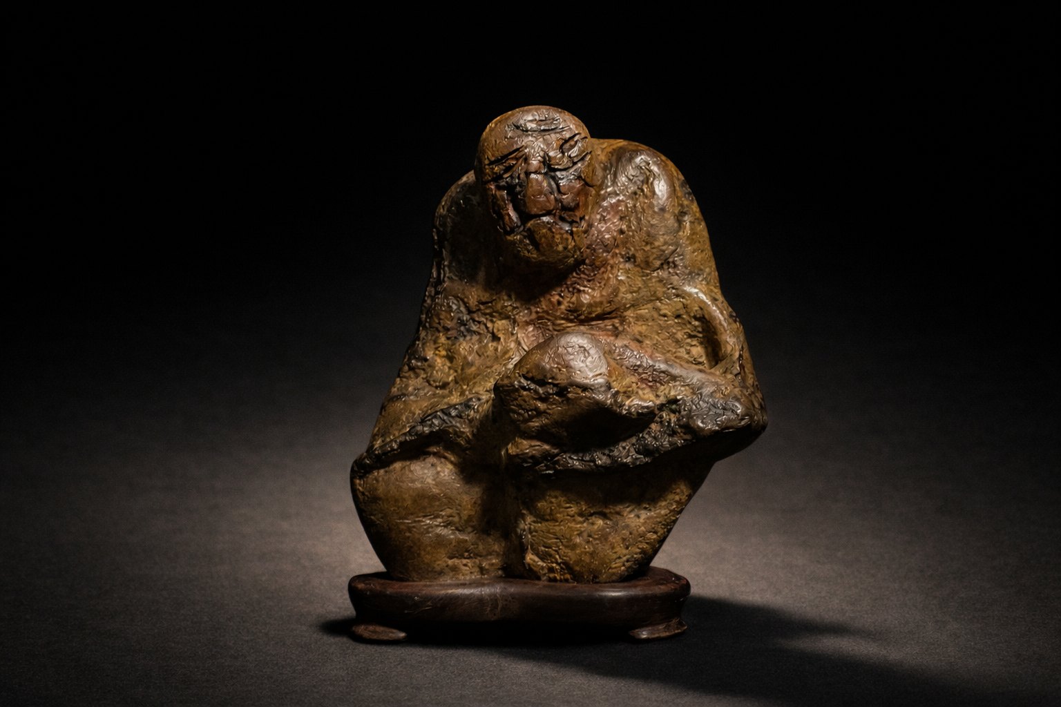 Human figure stone (Sugata-ishi) displayed on a custom-carved daiza. Its mysterious silhouette invites contemplation, allowing each viewer to discover a different presence or story within the stone.