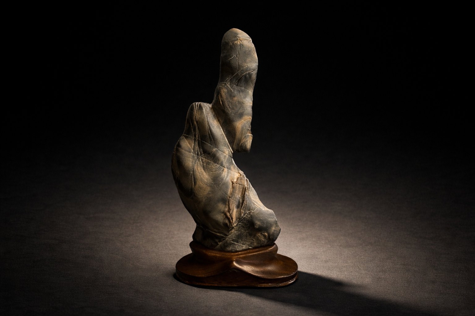Human figure stone (Sugata-ishi) displayed on a custom-carved daiza. Its silhouette evokes a resolute samurai of the late Heian or Kamakura periods, characterized by the distinct, backward-leaning form of a Hikitake-eboshi—the soft, lacquered cap traditionally worn by the warrior class beneath their helmets.